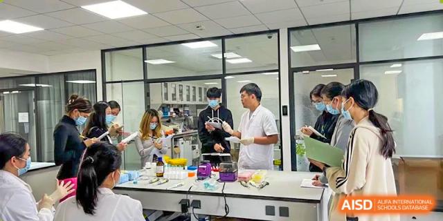 Students and teachers from The Affiliated High School of Peking University's Dalton Academy conducting experiments and collaborating in a bright, fully-equipped science laboratory.