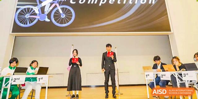 Two students standing on stage receiving awards or certificates during a competition or school ceremony at The Affiliated High School of Peking University's Dalton Academy.