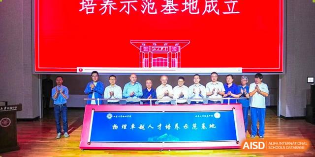 A panel of administrators and guests from The Affiliated High School of Peking University's Dalton Academy seated on a stage beneath a banner for a founding ceremony or event.