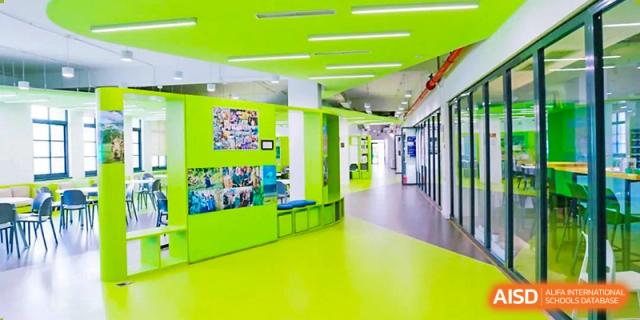 A bright, modern hallway and facility entrance at The Affiliated High School of Peking University's Dalton Academy featuring vibrant green and blue colors.
