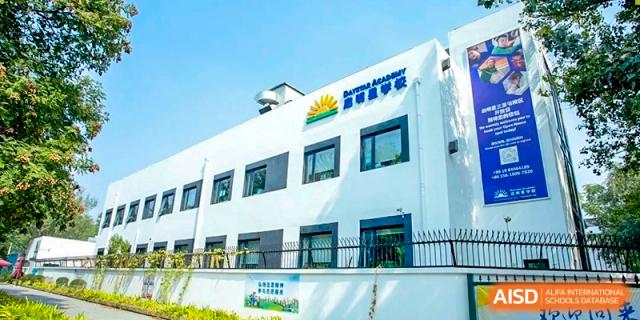DAYSTAR ACADEMY white school building exterior with blue trim on a sunny day.