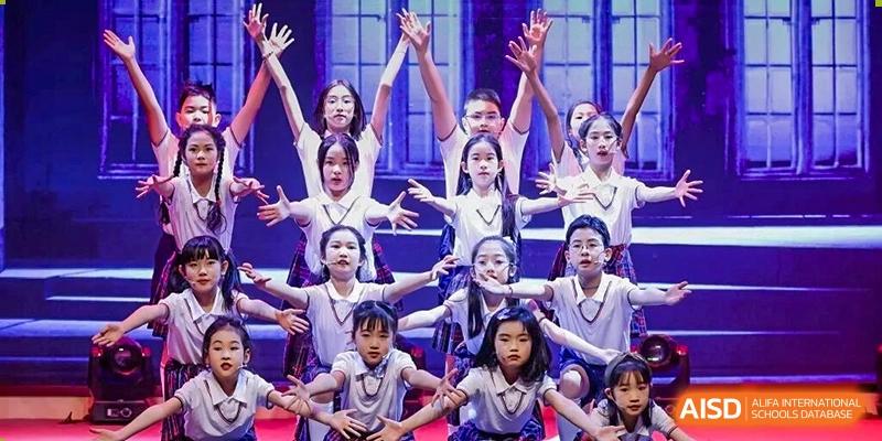 Students performing a choreographed dance on stage at a DAYSTAR ACADEMY performance or assembly.