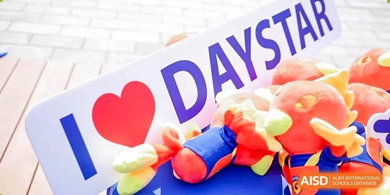 A close-up shot of a brightly colored banner or sign with the word "DAY" and some props at DAYSTAR ACADEMY.