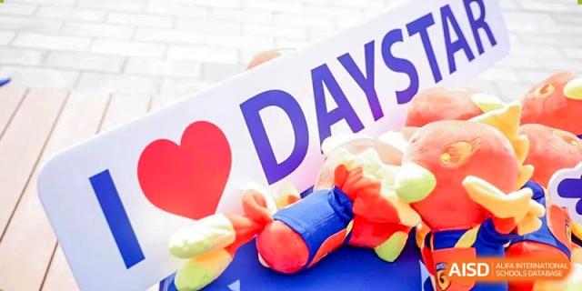 A close-up shot of a brightly colored banner or sign with the word "DAY" and some props at DAYSTAR ACADEMY.