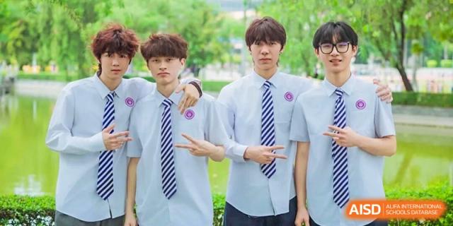 Two male students in school uniform and striped ties standing side-by-side and making a peace sign gesture, Fuyuan British American School.
