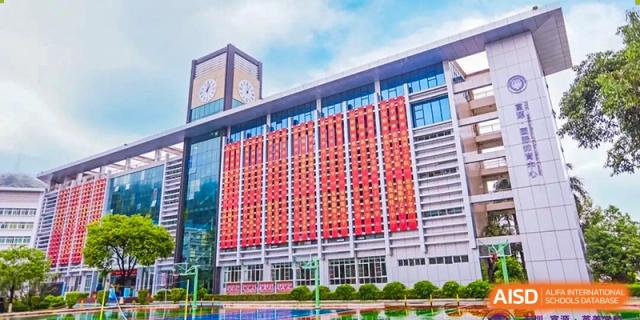 The modern exterior of a prominent building on the Fuyuan British American School campus with a unique red facade.