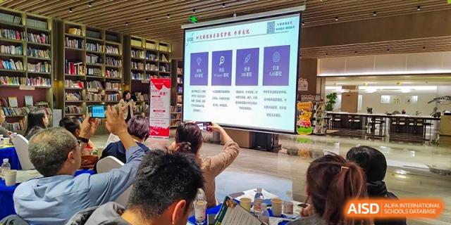 An individual is taking a photo of a presentation displayed on a screen during a school event or class at Guokai International School of Qingdao.