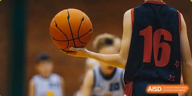 A student's hand holding a basketball on the court during a game at Harrow Lide High School Nanning.