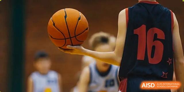 A student's hand holding a basketball on the court during a game at Harrow Lide High School Nanning.