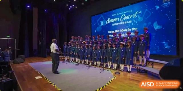 The student choir performing on stage at a Summer Concert inside Harrow Lide High School Nanning. Showcasing arts, music, and school events.