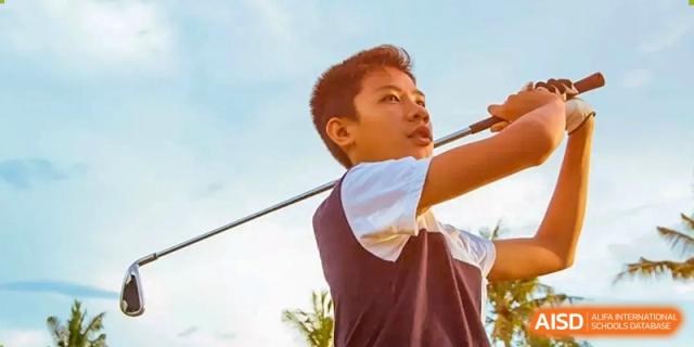 Harrow Lide High School Nanning student practicing his golf swing outdoors. Captures focus, blue sky, and sports education at the school.