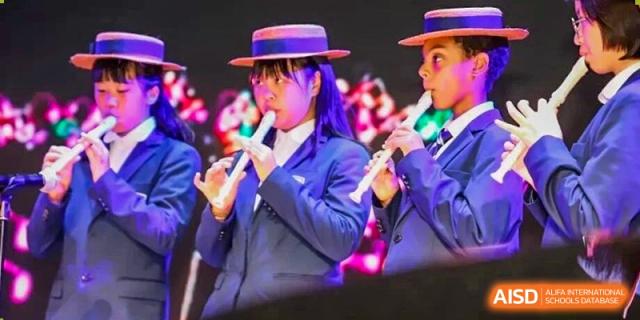 Harrow Lide High School Nanning students in uniform playing flutes as part of the vibrant marching band during an event.