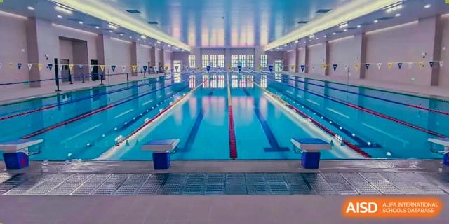 The modern, well-lit indoor swimming pool and lanes at Harrow Lide High School Nanning, ready for swimming lessons and training.