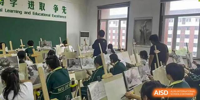 Students working on drawing or painting projects using easels in an art classroom at Maple Leaf International School-Zhenjiang.