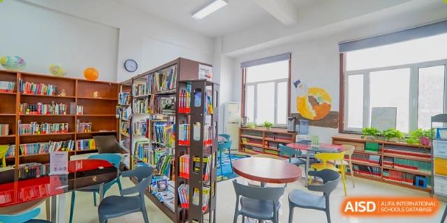 The colorful interior of a school library or resource center with bookshelves, a reading nook, and natural light at Maple Leaf International School-Zhenjiang.