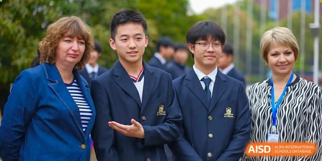 A close-up of male students in blue and white uniforms interacting on the school grounds at Maple Leaf International School-Zhenjiang.