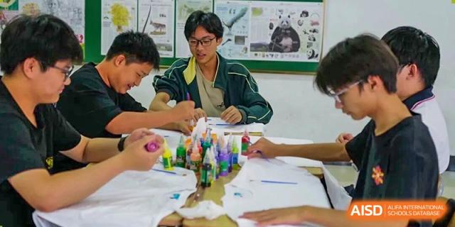 Students engaging in a creative activity, possibly painting or crafting, in a classroom at Maple Leaf International School-Zhenjiang.