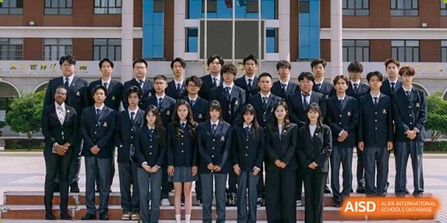 A group of high school students in dark uniforms posing for a formal portrait at Maple Leaf International School-Zhenjiang.