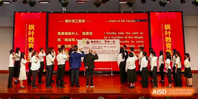 Students or staff members taking an oath or pledge on a stage during a ceremony at Maple Leaf International School-Zhenjiang.