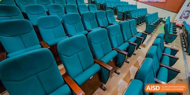 Rows of empty turquoise seats in the auditorium or lecture hall at Maple Leaf International School-Zhenjiang.