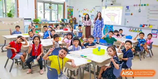 A teacher observing a classroom full of young students seated at desks for a lesson or activity at Shanghai High School International Division.