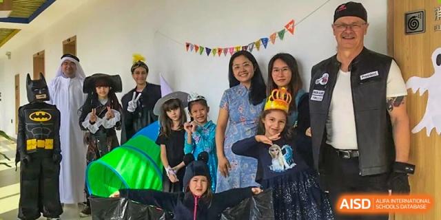 A group of Wenzhou Union International School (WUIS) students and adults in costumes, celebrating a school event or Halloween.