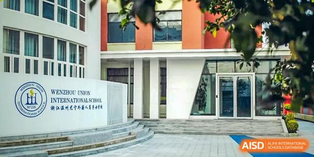 The modern entrance and exterior of a Wenzhou Union International School (WUIS) building with stairs leading up to the door.