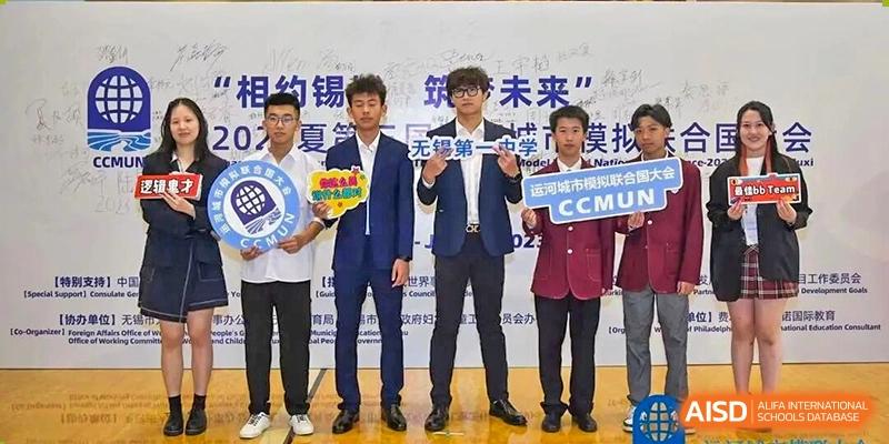 A group of male students in suits holding a competition banner for a science or innovation event at Wuxi No.1 High School.