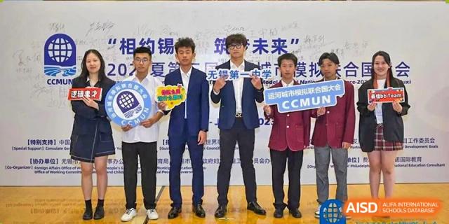 A group of male students in suits holding a competition banner for a science or innovation event at Wuxi No.1 High School.
