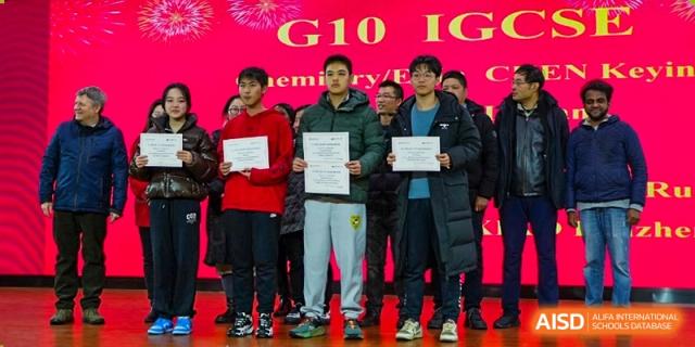 Three high school students holding award certificates after a competition or academic event at Wuxi No.1 High School.