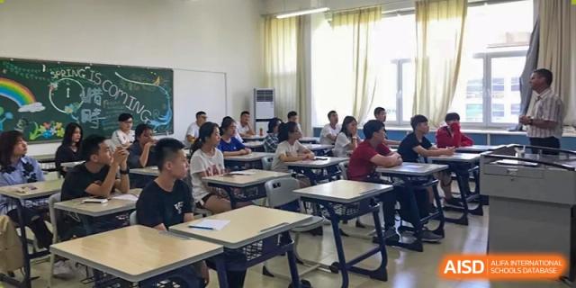 Students seated in a brightly lit classroom working at their desks during a lesson at Yang Guang Qing International School of Beijing.