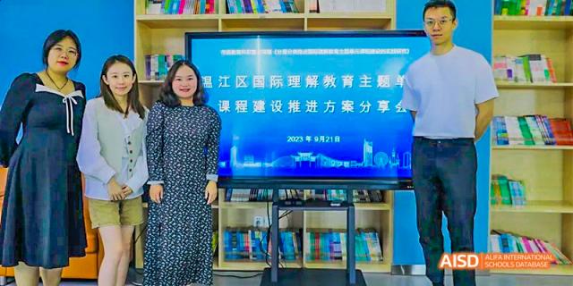A female teacher standing next to a large digital screen displaying Chinese text and a presentation title, for a training or sharing session, at 21ST Century School, Wenjiang, Chengdu.