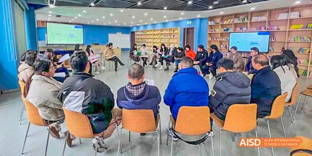 Students and adults seated in a circle in a school library or learning center for a group discussion or reading activity, at 21ST Century School, Wenjiang, Chengdu.