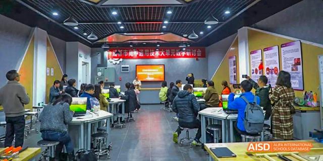 Students seated in a collaborative, modern learning space with movable tables, engaged in a group lesson or presentation, at 21ST Century School, Wenjiang, Chengdu.