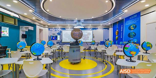 A high-tech circular classroom with flexible seating and a central robotic globe display, showcasing a modern learning environment, at 21ST Century School, Wenjiang, Chengdu.