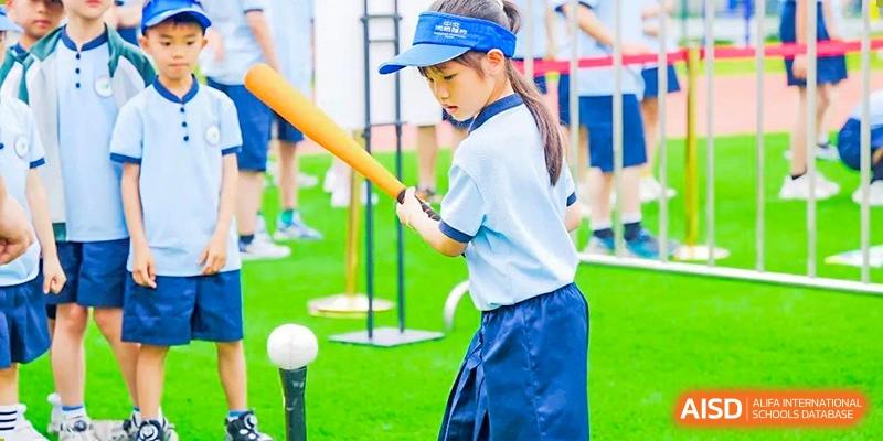 A female student in a uniform concentrating while practicing a swing with a baseball bat during a physical education class, at 21ST Century School, Wenjiang, Chengdu.