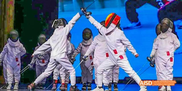 Three students dressed in white fencing gear with masks, cheering with their swords raised after a match or during a training session, at 21ST Century School, Wenjiang, Chengdu.