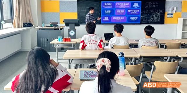 Students seated in a classroom with their backs to the camera, watching a male teacher lecture at a smart board at BDA School of The High School Affiliated to Renmin University of China.