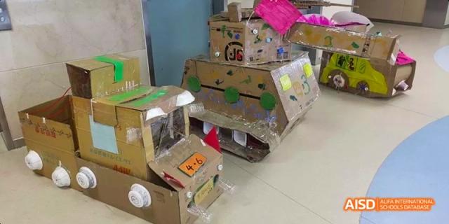 A student-made project, possibly a vehicle or robot, constructed from painted cardboard at BDA School of The High School Affiliated to Renmin University of China.