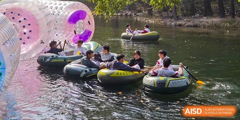 Students floating in inner tubes on a body of water, participating in an outdoor recreation activity at BDA School of The High School Affiliated to Renmin University of China.