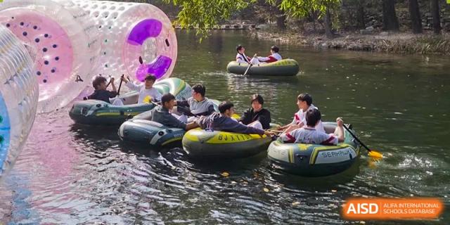 Students floating in inner tubes on a body of water, participating in an outdoor recreation activity at BDA School of The High School Affiliated to Renmin University of China.