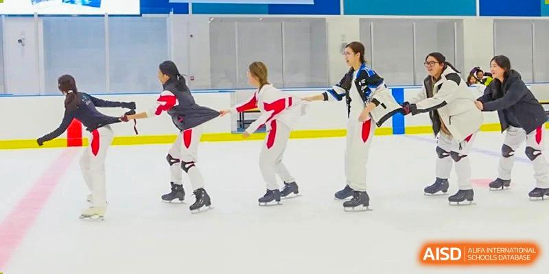 Students dressed in ice skating attire gliding on an indoor or outdoor rink at BDA School of The High School Affiliated to Renmin University of China.