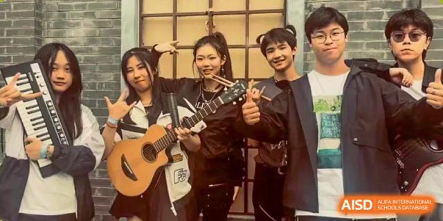 A group of students taking a close-up photo while one plays an acoustic guitar at BDA School of The High School Affiliated to Renmin University of China.