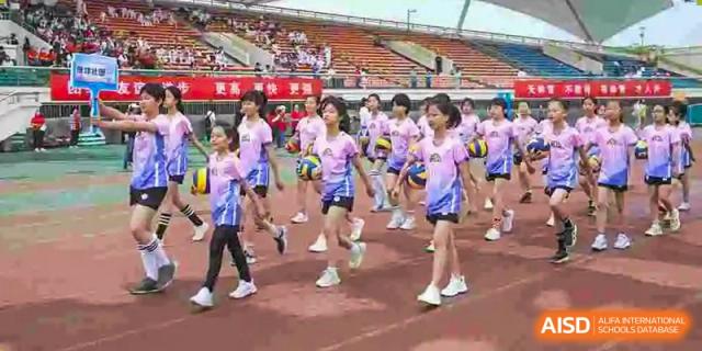 A group of female students in pink and white uniforms running or exercising on a track at BDA School of The High School Affiliated to Renmin University of China.