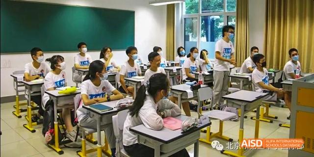 Students from Beijing No.2 Middle School sitting at their desks, engaged in a lesson or discussion in a brightly lit, modern classroom.