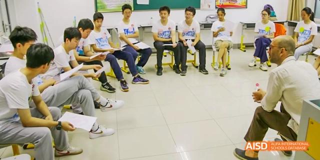 Students from Beijing No.2 Middle School sitting in a small circle during a group discussion or workshop.