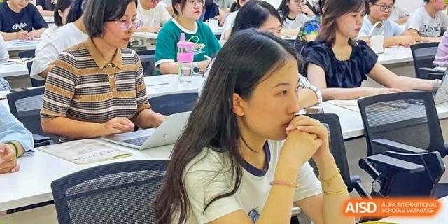 A female student from The International School of Rhodes listening attentively during a lesson in a classroom.