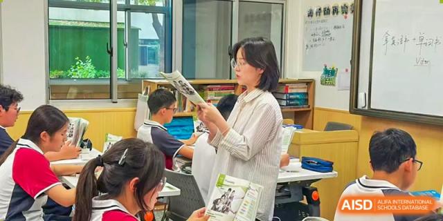 A teacher or staff member from The International School of Rhodes reading a newspaper or materials in a bright, informal setting.