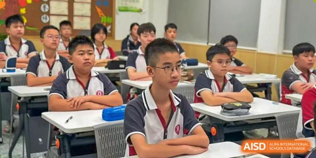 A male student from The International School of Rhodes focused on the teacher during a class.