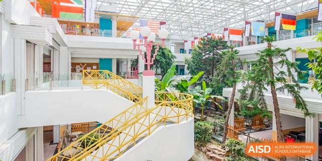 A view of a bright outdoor playground or learning structure with yellow railings and plants at The International School of Rhodes.